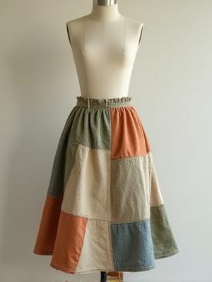 Artistic patchwork skirt made from various natural fabric scraps, displaying '100% Biodegradable' badge