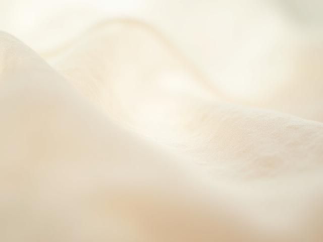 Close-up of loosely woven linen fabric, showing natural texture and breathability