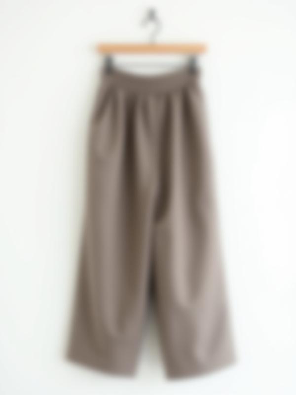 Pair of comfortable, wide-leg linen trousers in an earthy tone on a hanger